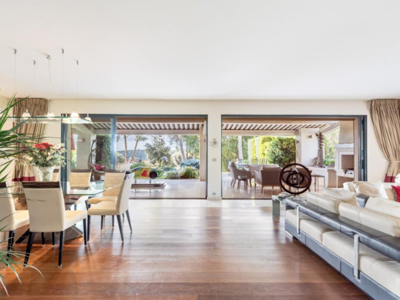 Interior of a modern villa with living room and dining room open to the outside.