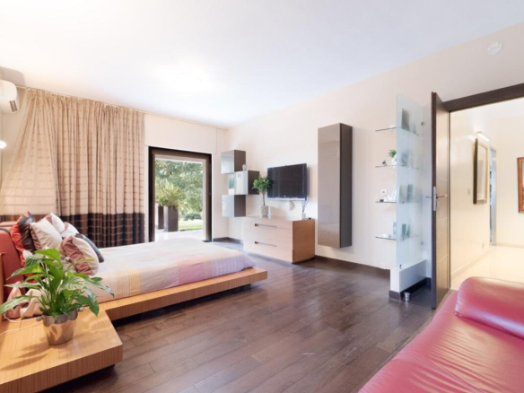 Modern room with bed, television and access to the outside in a villa in Biot.