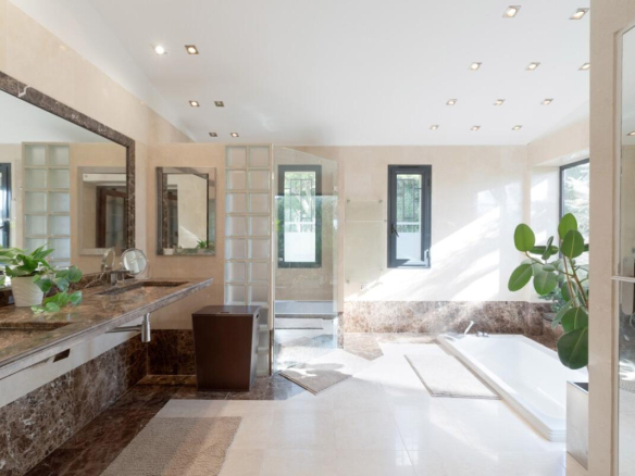 Spacious bathroom with bathtub and large windows in a villa in Biot.