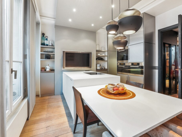 Modern kitchen with dining table and high-end appliances in an apartment in Paris 7th arrondissement.