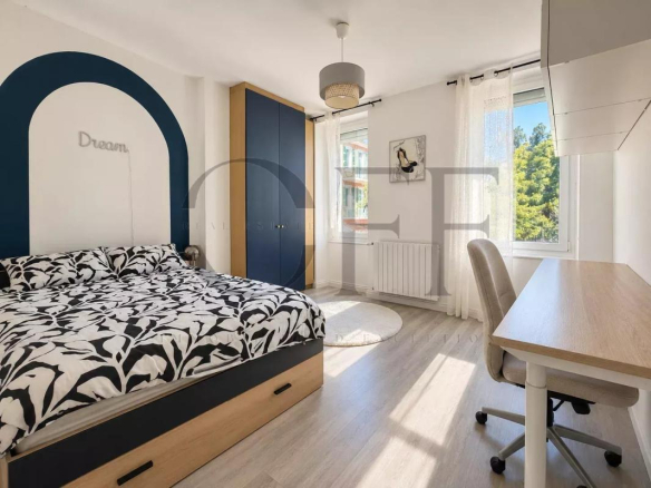 Room with double bed and desk in a townhouse in Marseille 7th arrondissement.