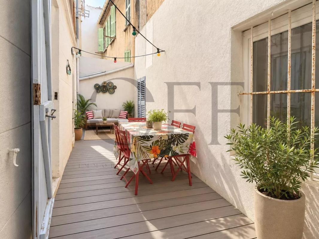 Courtyard terrace of a townhouse in Marseille Courtyard-terrace of a townhouse in Marseille 7th, with table and chairs, decorated with plants.