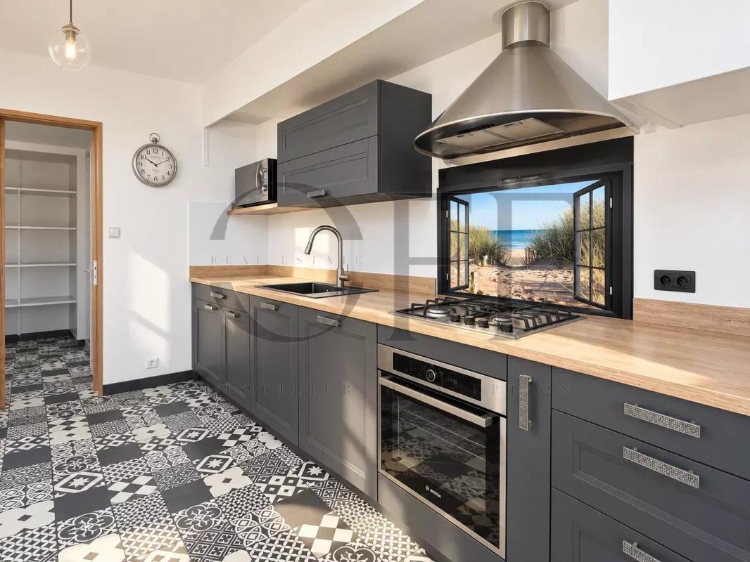 Townhouse kitchen in Marseille Modern kitchen with grey cabinets and decorative tiles
