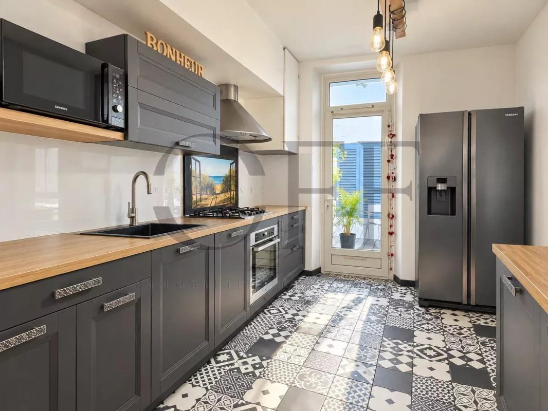 Townhouse kitchen in Marseille Modern kitchen with grey cabinetry and decorative tiled flooring, Marseille 7th arrondissement