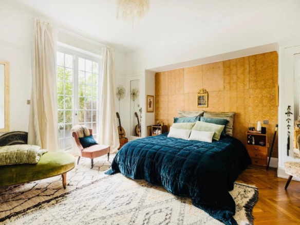 Chambre d'un duplex à Strasbourg avec lit, fauteuils et accès à un jardin.