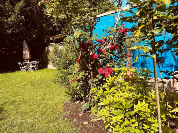 Jardin privatif avec fleurs et mobilier de jardin dans un duplex à Strasbourg.