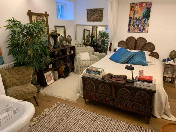 Chambre d'un duplex avec lit, décoration chaleureuse et plantes d'intérieur.