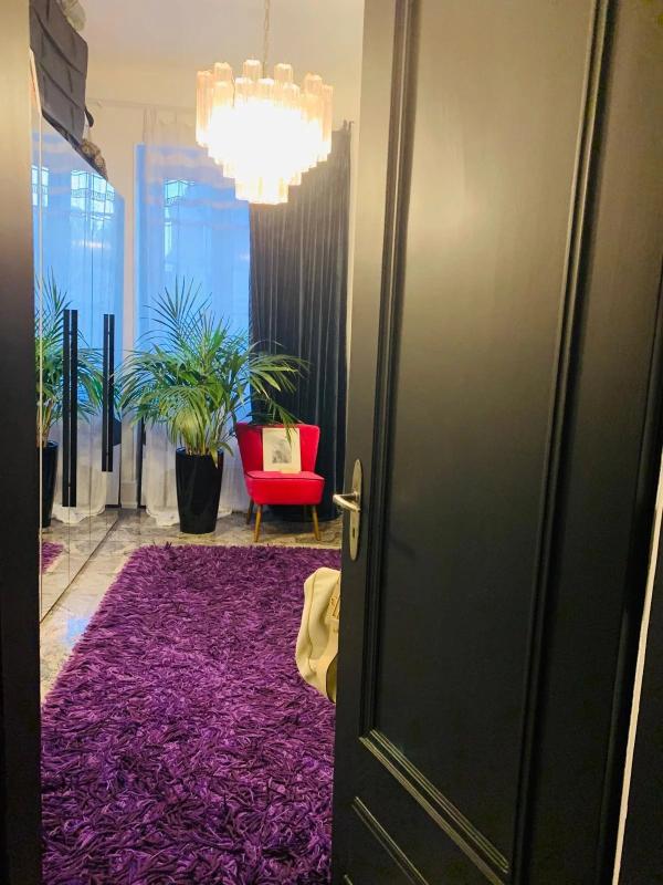 Intérieur d’un duplex à Strasbourg Vue intérieure d'un duplex avec un tapis violet, une chaise rouge et des plantes, Strasbourg.