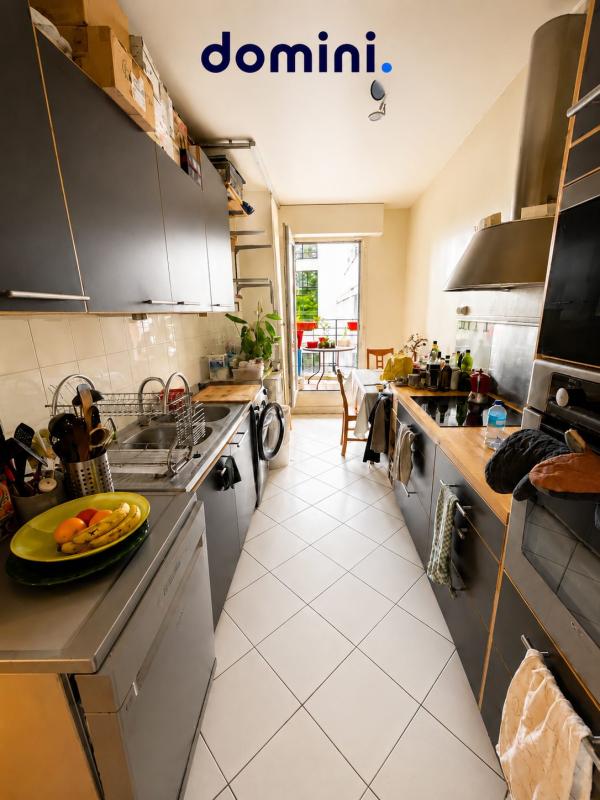 Cuisine d’un appartement à Montrouge Cuisine d'un appartement avec des meubles modernes et un accès à une terrasse.