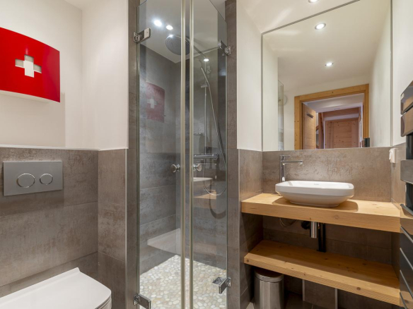 Salle de bain moderne avec douche, lavabo et toilettes dans un duplex à Avoriaz.