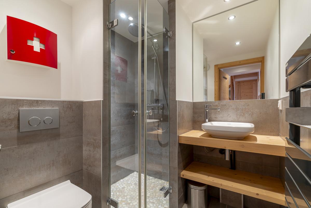 Salle de bain du duplex Kouria Salle de bain moderne avec douche, lavabo et toilettes dans un duplex à Avoriaz.