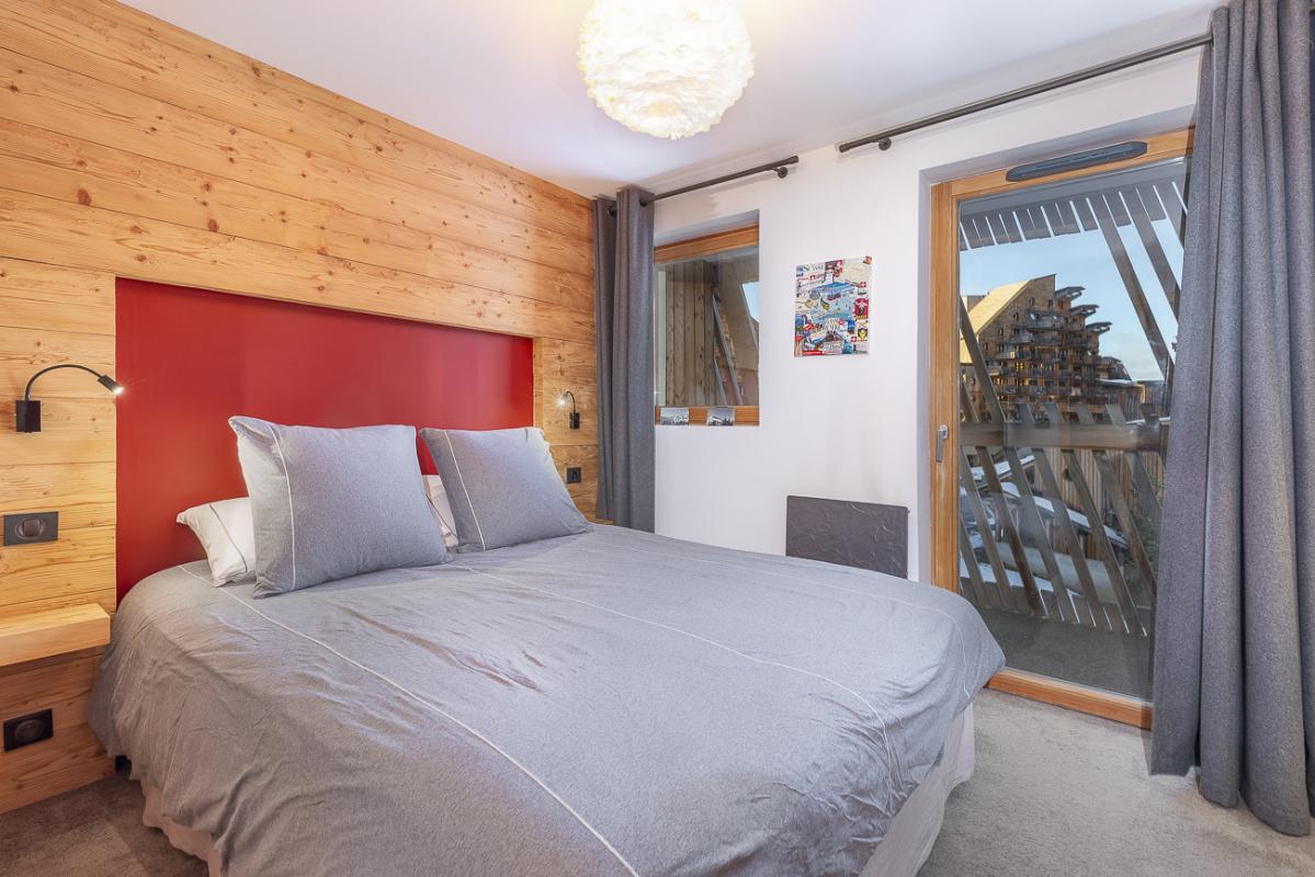 Chambre du duplex à la résidence du Kouria Chambre d'un duplex avec lit double et balcon, décor en bois à Avoriaz.