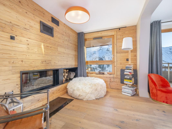 Intérieur d'un duplex avec un salon en bois, cheminée et vue sur la montagne à Avoriaz.