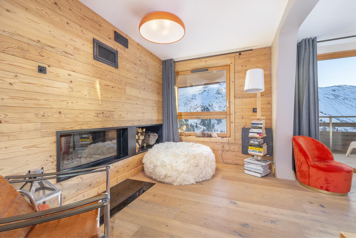 Intérieur d’un duplex à Avoriaz Intérieur d'un duplex avec un salon en bois, cheminée et vue sur la montagne à Avoriaz.