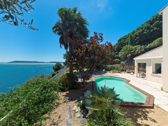 Villa avec piscine et vue sur l'étang à Istres, entourée de végétation.