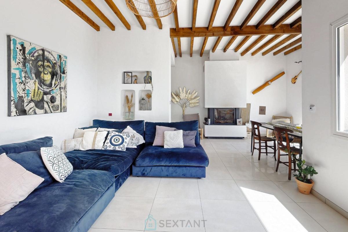 Intérieur d’une villa à Istres Intérieur d'une villa moderne avec un grand canapé bleu et des poutres apparentes.