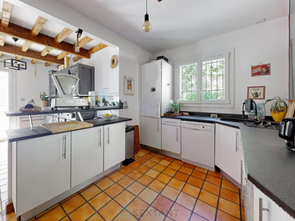 Cuisine moderne dans une villa à Istres avec carrelage en terre cuite et meubles blancs.