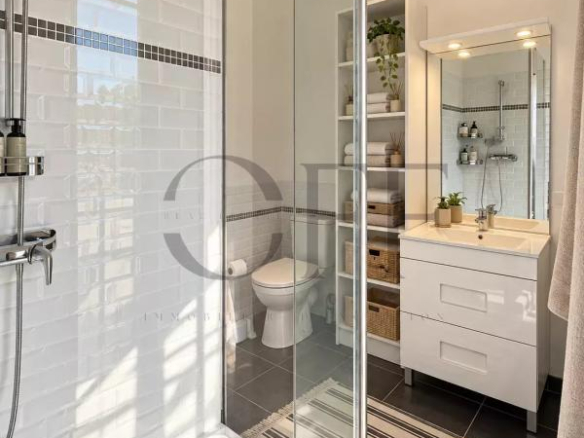 Salle de bain moderne avec douche à l'italienne et meuble lavabo.