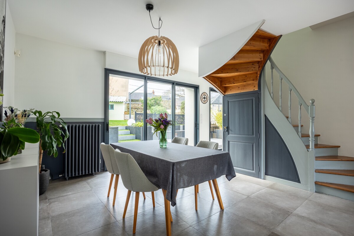 Interior of a house in Nantes with dining room, wooden staircase and natural light.