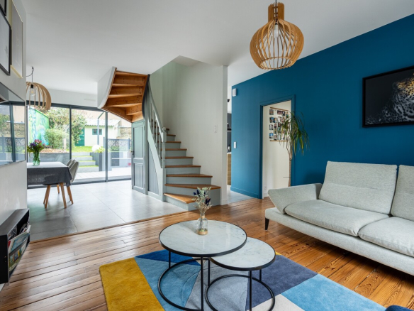 Interior of a modern house with living room, staircase and access to a garden.