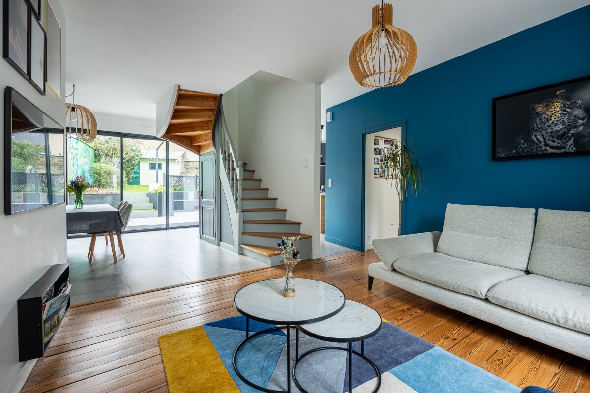 Interior of a modern house with living room, staircase and access to a garden.
