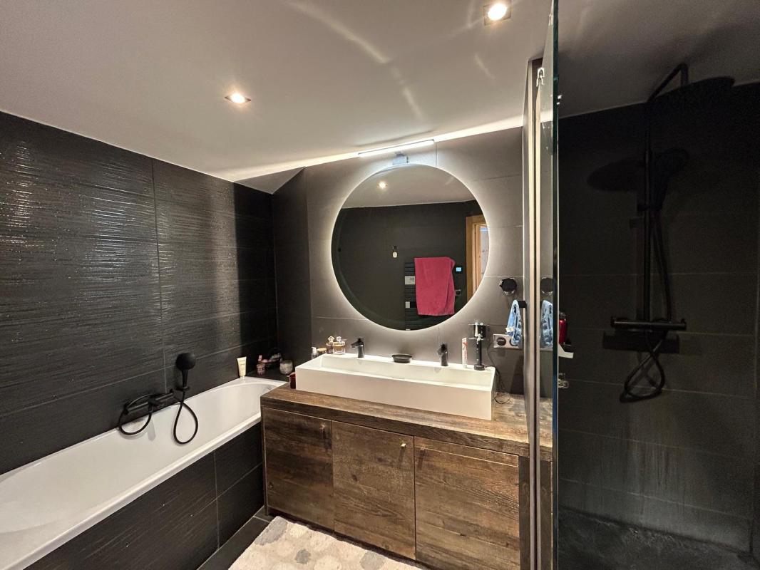 Bathroom of the duplex apartment Modern bathroom with bathtub and shower, soft lighting.