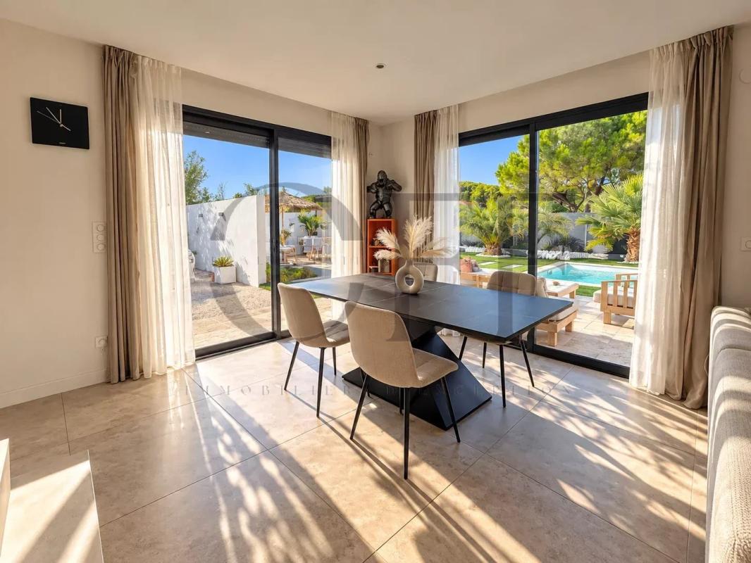 Interior of a contemporary villa in Le Rove Interior of a contemporary villa with dining room and pool view.