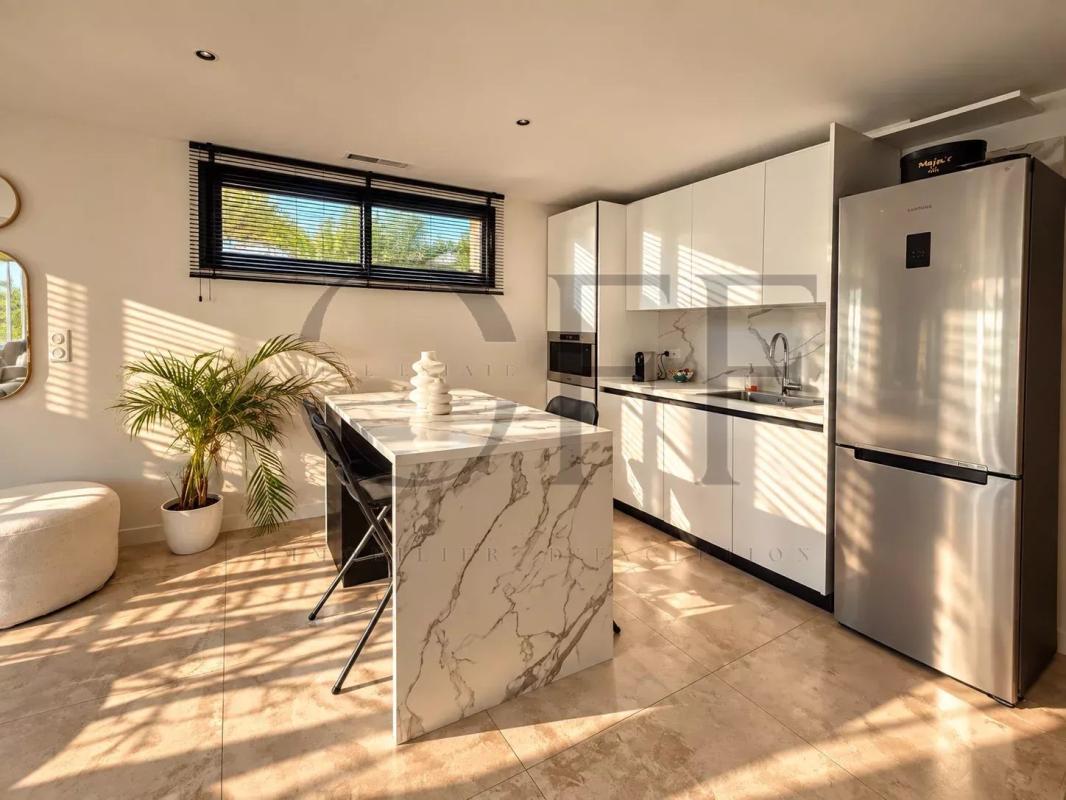 Kitchen of a Californian villa in Le Rove Modern and bright kitchen in a contemporary villa with central island and stainless steel appliances.