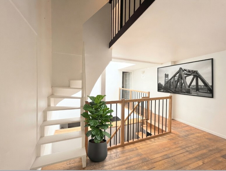 Intérieur d’une maison à Paris Intérieur d'une maison avec un escalier en colimaçon et un mur décoré d'une photo en noir et blanc.