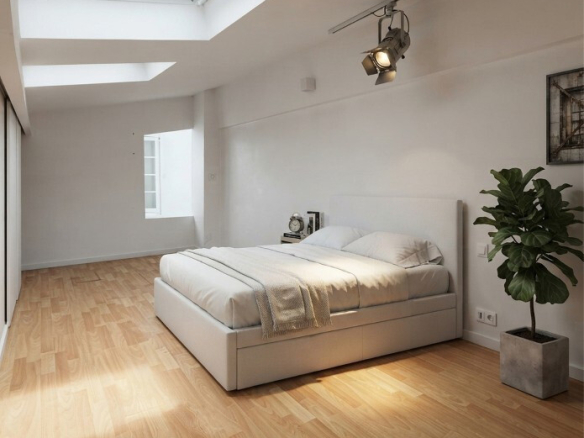 Chambre lumineuse avec lit double et parquet en bois, éclairée par un puits de lumière.