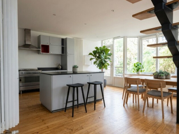 Intérieur d'une maison atypique à Paris avec cuisine ouverte et salle à manger lumineuse.