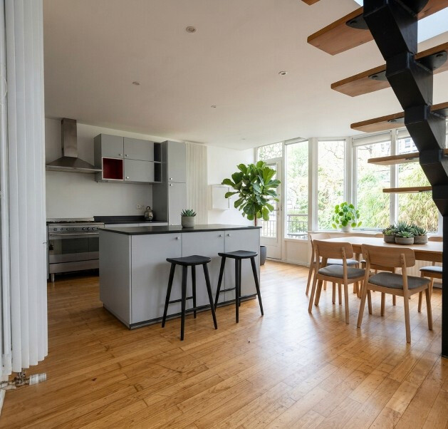 Maison atypique à Paris Intérieur d'une maison atypique à Paris avec cuisine ouverte et salle à manger lumineuse.