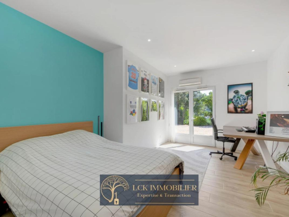 Chambre d'une villa contemporaine avec un mur bleu et accès à l'extérieur, Roquebrune-sur-Argens.