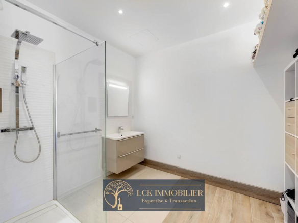 Salle de bain moderne avec douche à l'italienne et meuble sous lavabo.