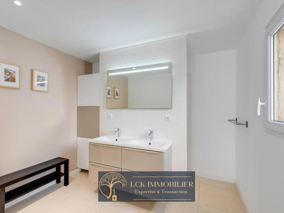 Salle de bain moderne avec double vasque et miroir lumineux.