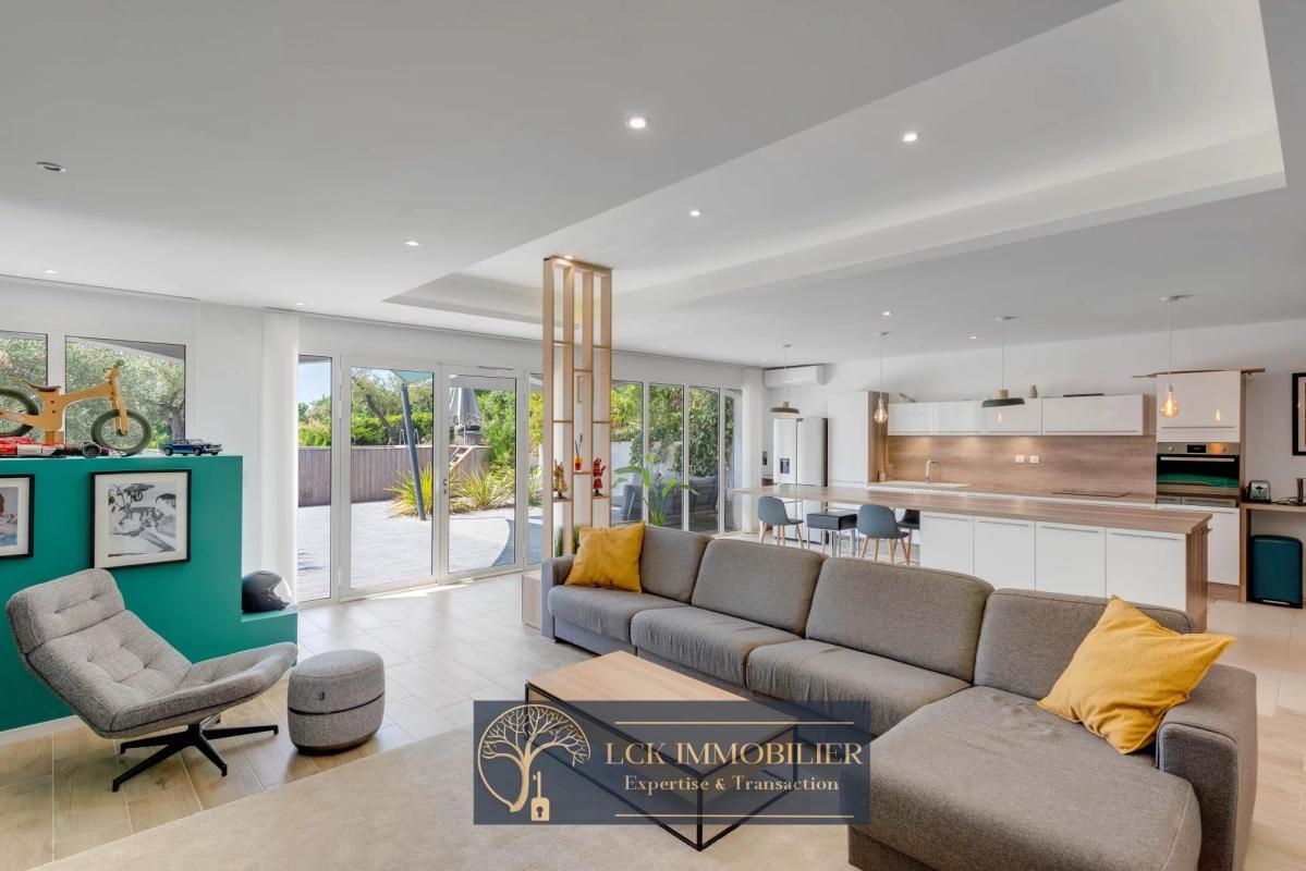 Intérieur d’une villa contemporaine Intérieur d'une villa contemporaine avec salon spacieux et cuisine ouverte, vue sur l'extérieur.