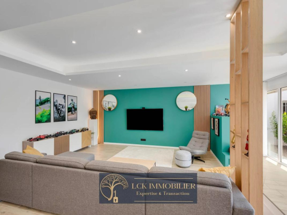 Intérieur d'une villa contemporaine avec un salon spacieux et moderne, murs verts et baies vitrées.