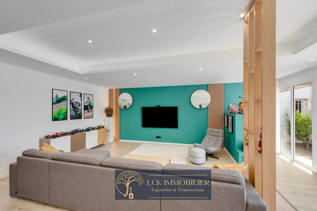 Intérieur d’une villa contemporaine Intérieur d'une villa contemporaine avec un salon spacieux et moderne, murs verts et baies vitrées.