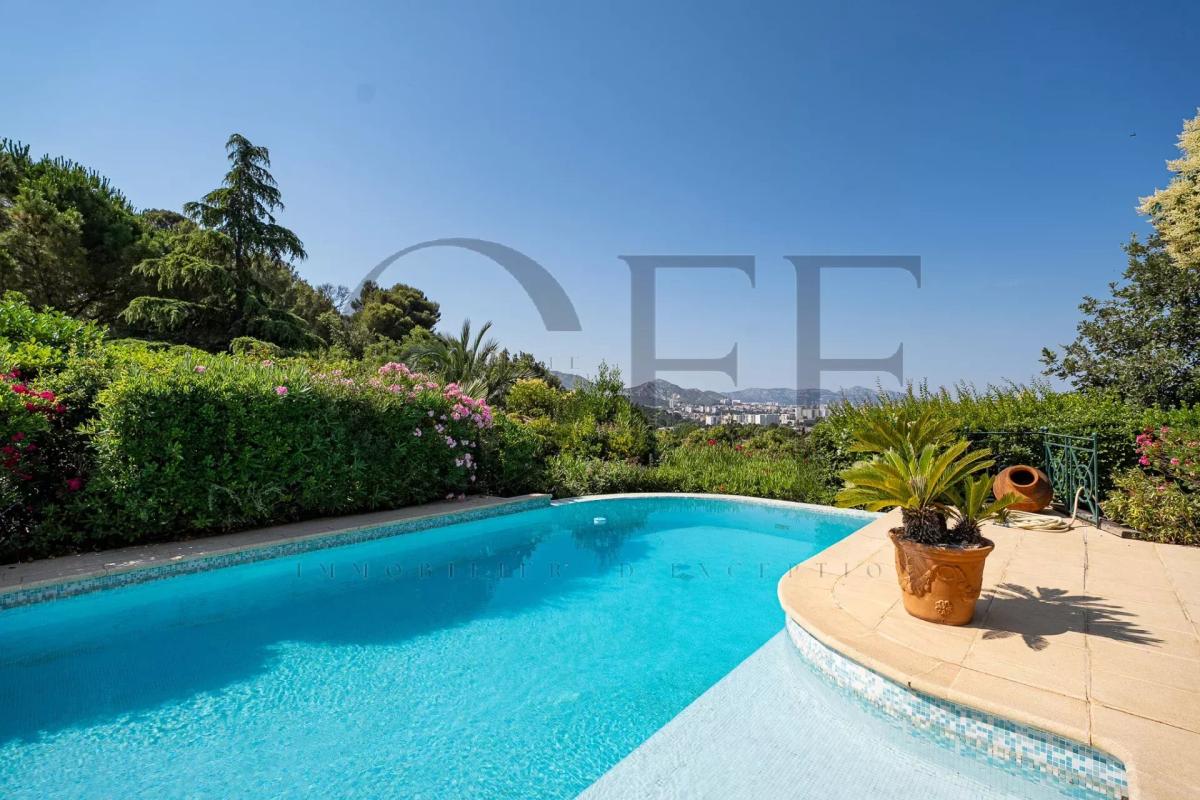 Villa d’exception à Marseille 12ᵉ Vue de la piscine d'une villa avec jardin à Marseille 12ᵉ, entourée de végétation.