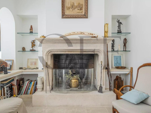 Intérieur d'une villa d'exception à Marseille avec cheminée et étagères décoratives.