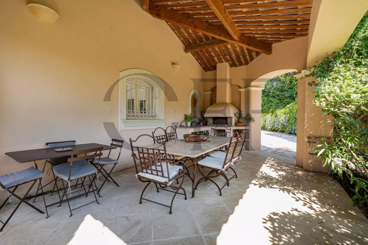 Terrasse de villa à Marseille 12ᵉ Terrasse couverte avec table et chaises, entourée de verdure dans une villa à Marseille 12ᵉ.