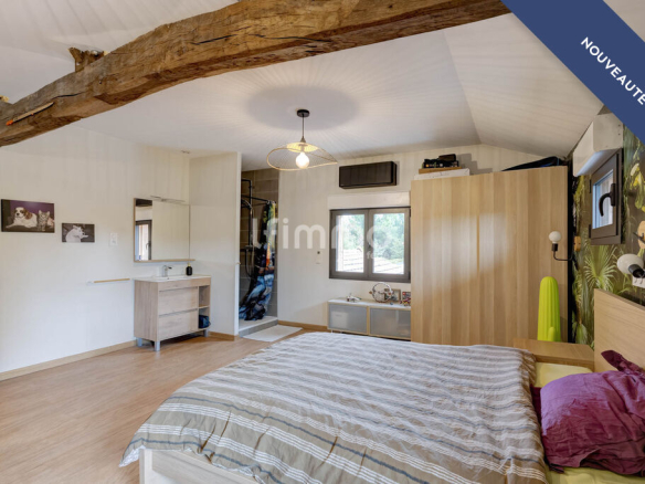 Bedroom in a renovated property with wooden elements and a desk area.
