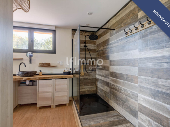 Modern bathroom with walk-in shower and wood decor.