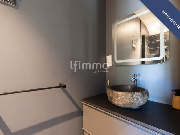 Modern bathroom with stone sink and mirror in a renovated setting.