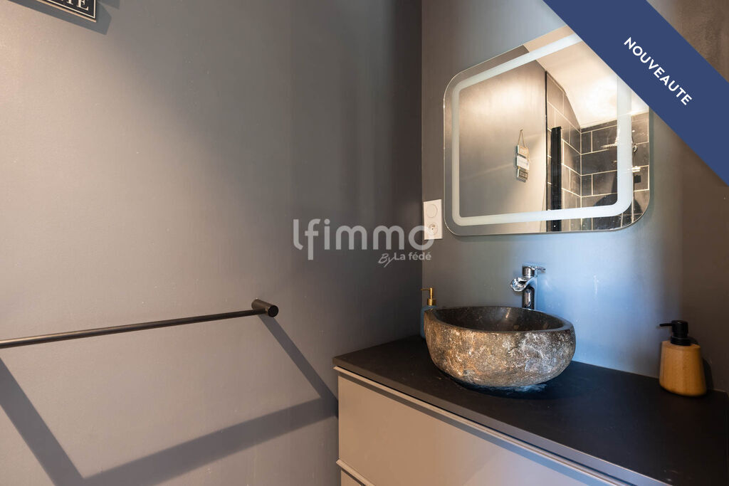 Renovated bathroom Modern bathroom with stone sink and mirror in a renovated setting.