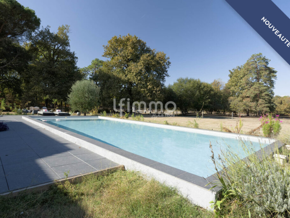 Outdoor swimming pool in a natural setting surrounded by trees, Le Barp