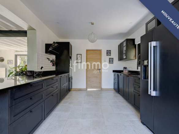 Modern kitchen in a renovated house with black furniture and marble surfaces.
