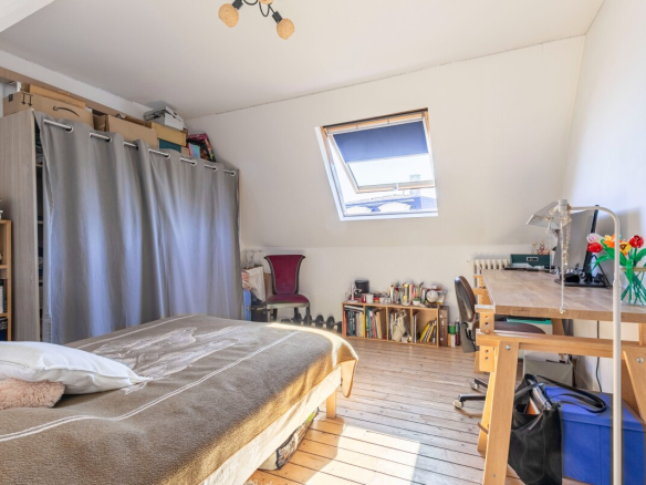 Chambre d'une maison à Fontenay-aux-Roses avec lit, bureau et étagères.