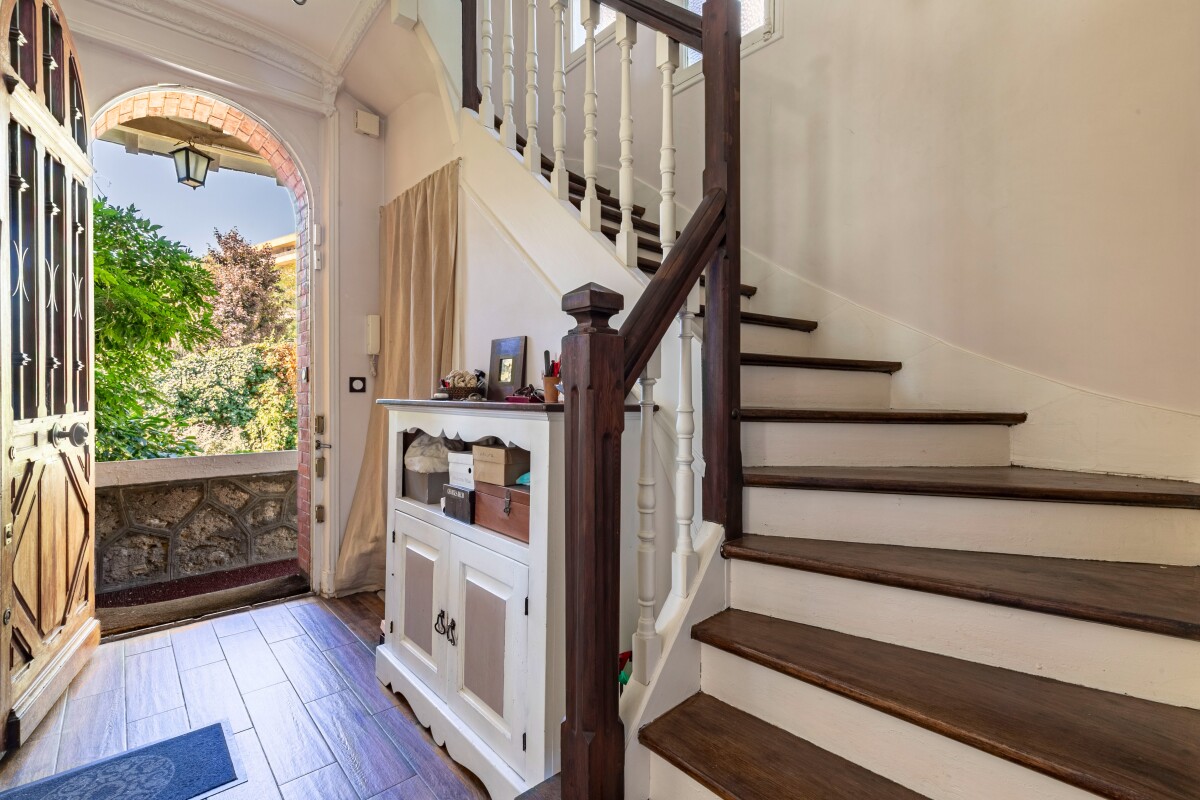 Hall d’entrée d’une maison meulière Intérieur d'une maison meulière avec un hall d'entrée et un escalier en bois.