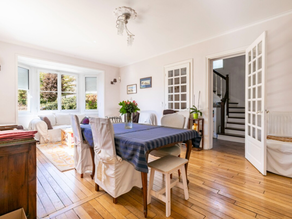 Intérieur d'une maison meulière à Fontenay-aux-Roses, avec un salon lumineux et une table à manger.